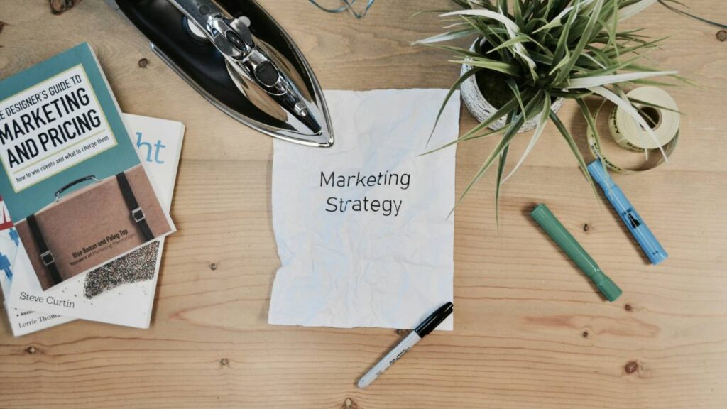 A paper with "marketing strategy" written on it on a table
