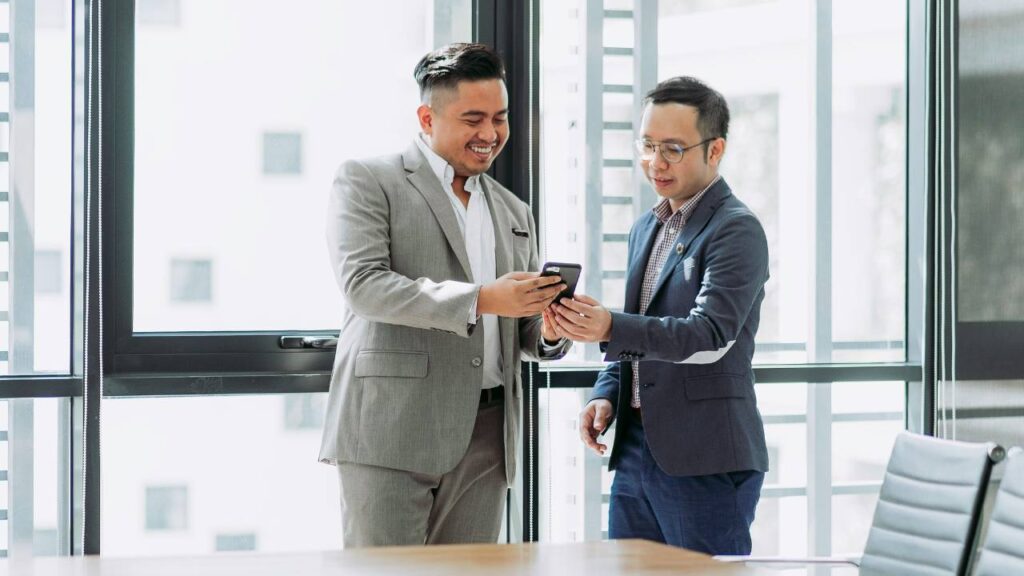Two Asian businessmen talking in an office setting