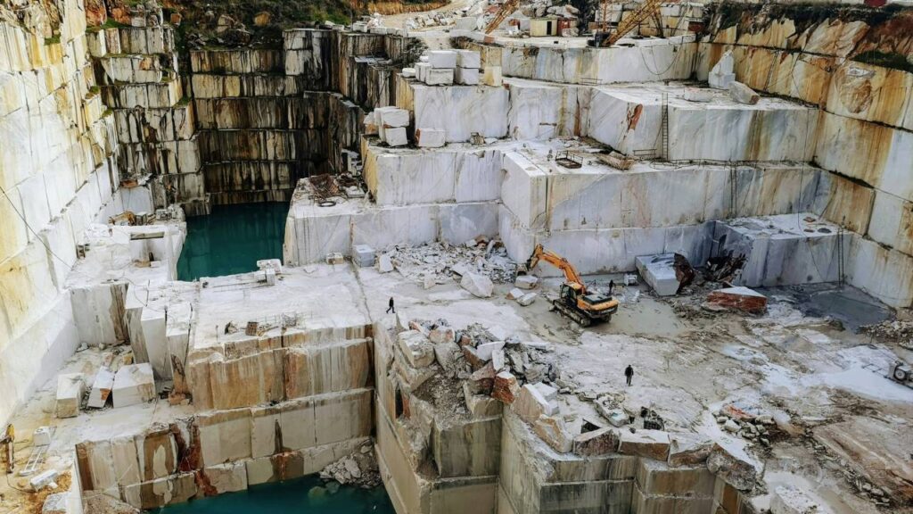 A large quarry with an excavator in it