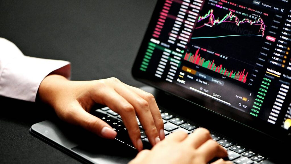 A man using a laptop to perform financial analysis