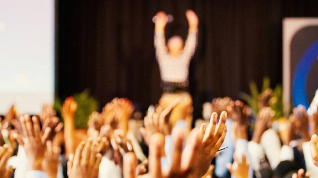 People waving their hands at a business event