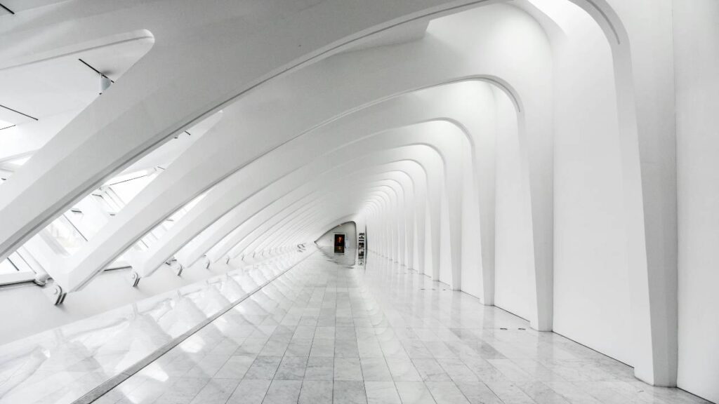 A long hallway with white walls and flooring