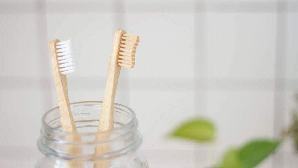 A couple of wooden toothbrushes in a glass jar