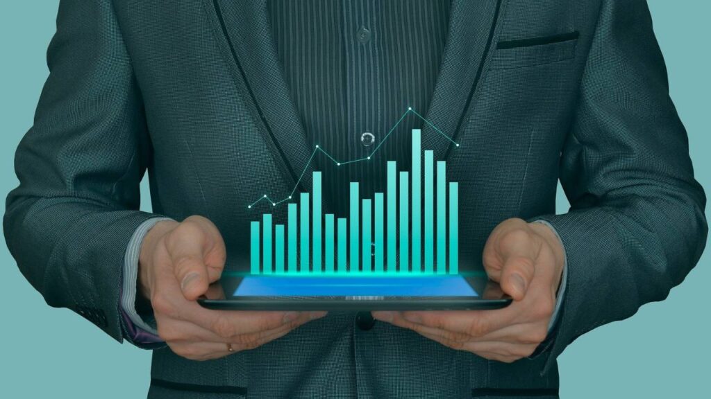 An abstract image depicting a man holding a tablet with a 3D growth graph on its display 