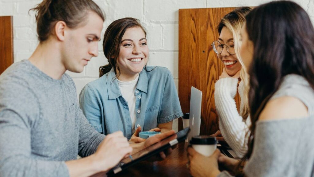 Three female employees and one male employee sharing a laugh 