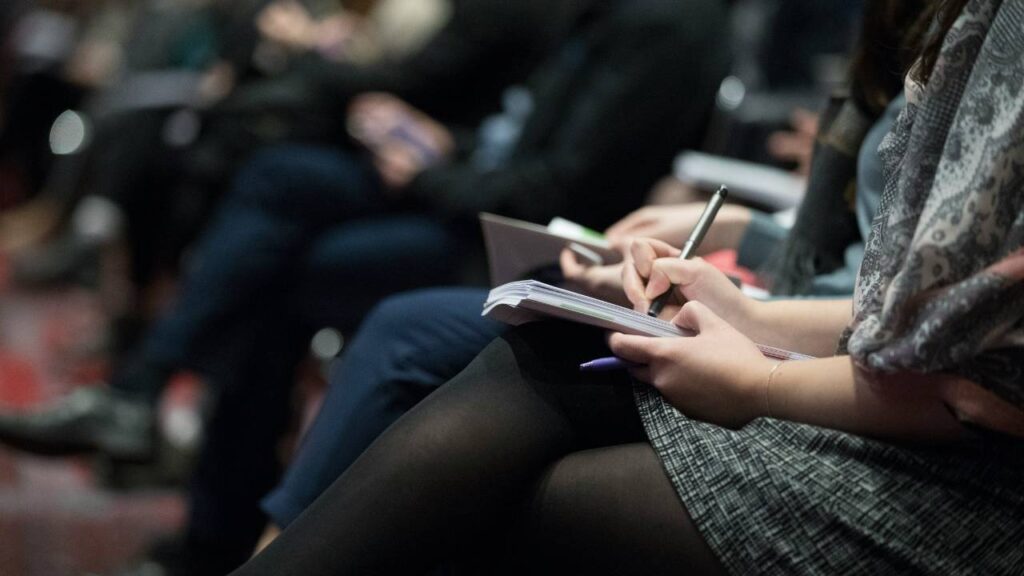 A woman taking notes at a business seminar 