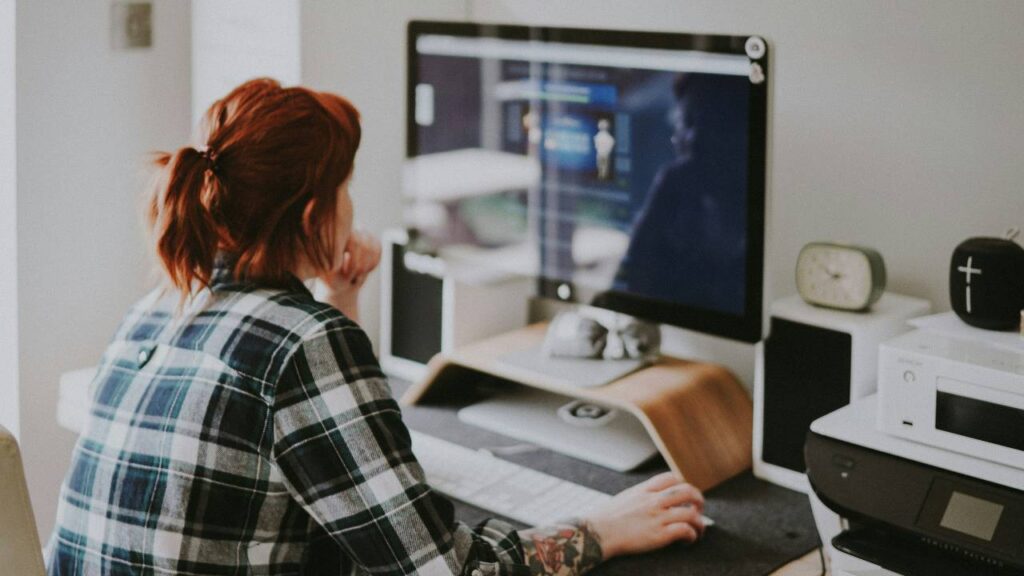 A red-haired girl working on a computer