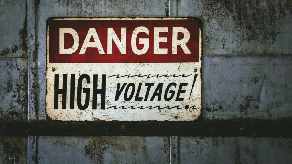 A metal sign saying "danger - high voltage" 