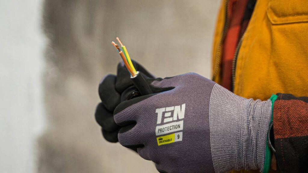 A repairman holding two exposed electrical wires
