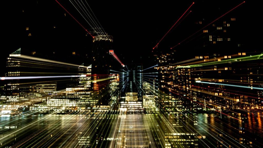 A city's skyline in the night as seen through a reflective window